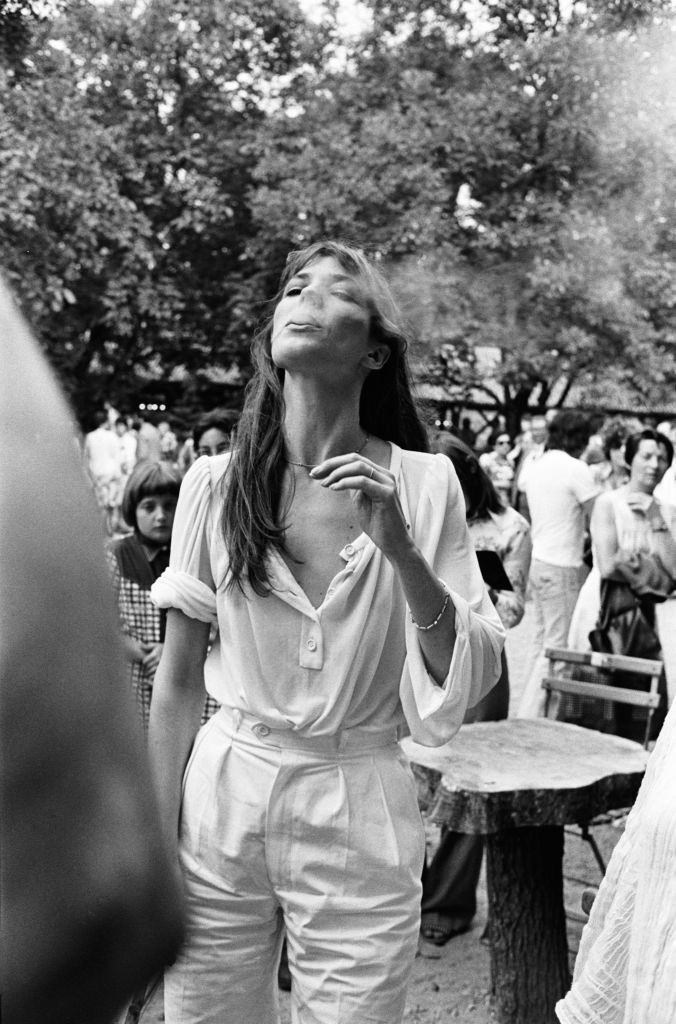 Jane Birkin usando camisa de botão e calça, claras e de modelagens soltas